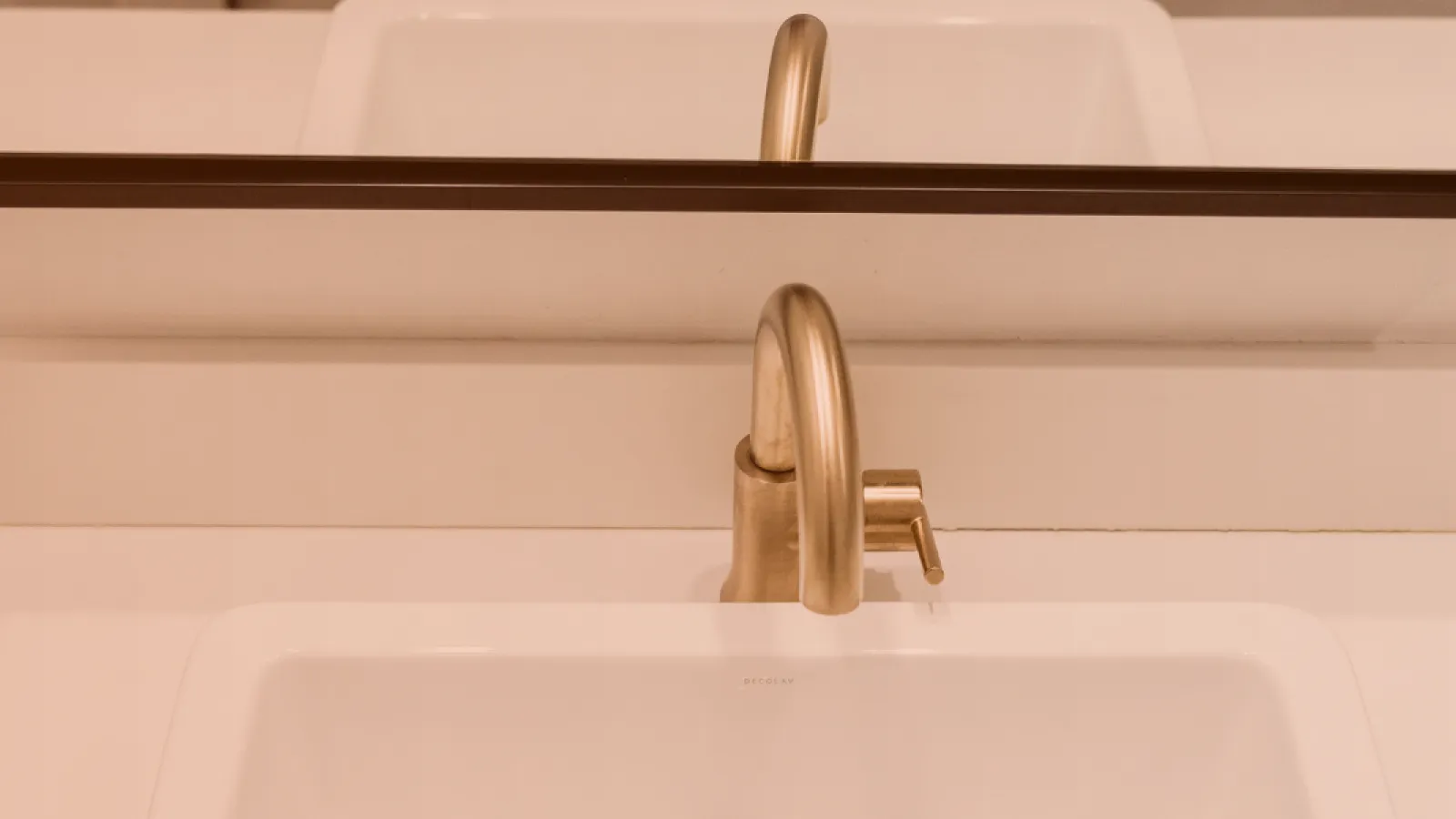 Grifo de latón en un lavabo con espejo